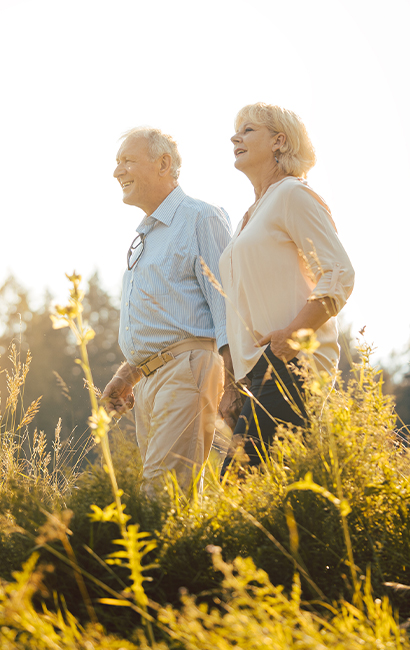 happy senior couple walking in field retirement strategies greene financial michigan